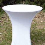 A round white table placed on green grass, creating a serene outdoor setting for relaxation or dining.