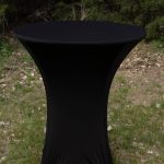 A black-covered table positioned on lush green grass, blending elegance with nature.